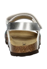 Zilveren en witte sandaal met een kurken voetbed, verstelbare band en kralenaccenten aan de zijkant. Gemozaïekte bovenkant en stevige zool.