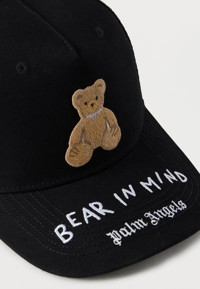 Μαύρο καπέλο με κεντημένο σταμπωτό αρκουδάκι και λευκό κείμενο "BEAR IN MIND Palm Angels" στην μπροστινή πλευρά. Υλικό από βαμβάκι.