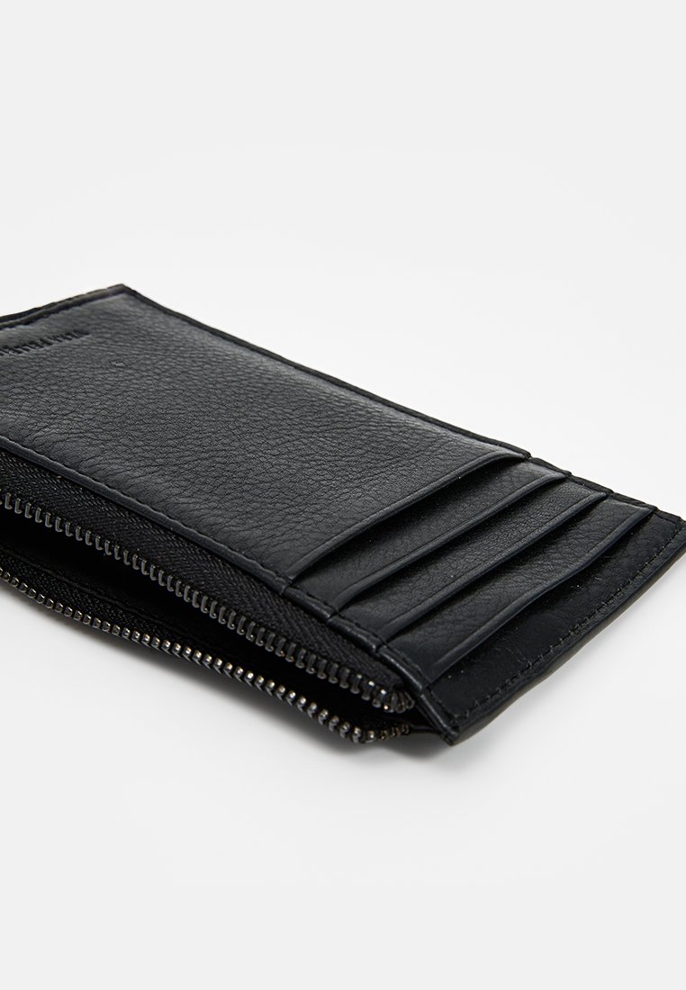 Billetera de cuero negro con múltiples ranuras para tarjetas, cierre con cremallera a lo largo de un borde, acabado texturizado y un forro interior suave.