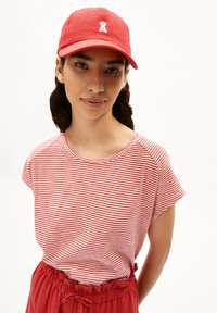 Red baseball cap with white logo, striped red and white short-sleeve shirt, and red elastic waist pants with tie detail.