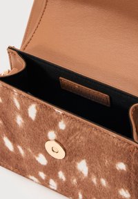 Τσαντάκι χιαστί από ψεύτικη γούνα σε καφέ και ταμπά αποχρώσεις με χρυσό μαγνητικό κούμπωμα και μαύρο υφασμάτινο εσωτερικό, ανοιχτό για να φαίνεται η εσωτερική ετικέτα.