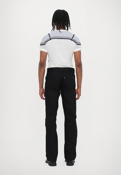 Pantaloni negri cu picioare drepte și buzunare, asortați cu un tricou cu dungi alb și gri, având mâneci din plasă.