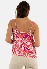 Camisola floreale in toni di rosa e corallo con un motivo a spirale, caratterizzata da spalline sottili e un tessuto leggero. Design della schiena semplice.