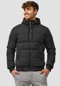 Schwarze Daunenjacke mit Kapuze, mit einem gesteppten Design, Reißverschluss-Taschen und braunen Lederakzenten. Gerippte Bündchen und Saum.