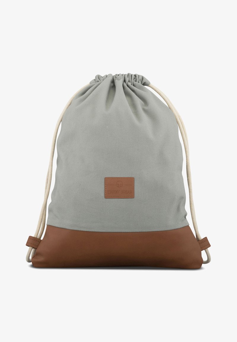 Dragsäck i ljusgrå canvas med botten av brunt läder. Har en logotyp-patch och krämfärgade dragsnören.