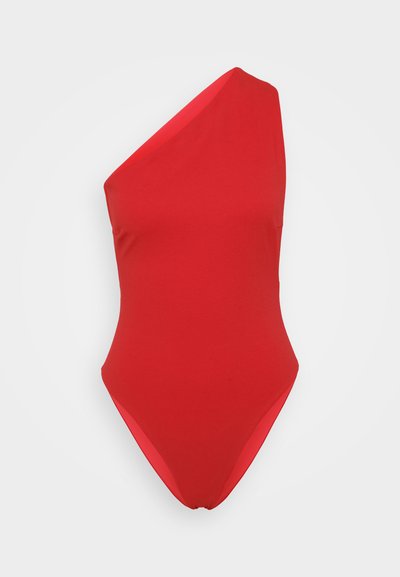 Punane üheosaline bikiinimudel, millel on üks õlavarre rihm, valmistatud siledast ja venivast kangast, kõrge lõikega jalgadega ja minimalistik disainiga.
