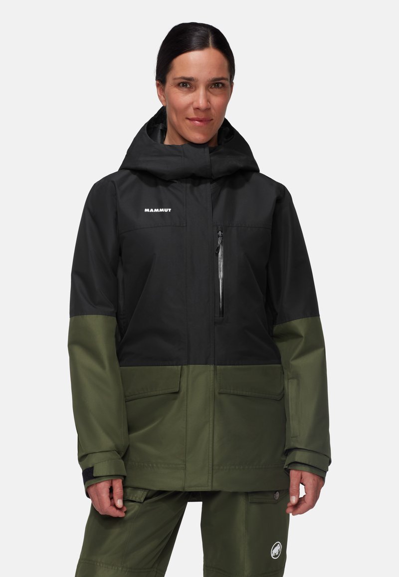 Giacca impermeabile nera e verde con cappuccio, tasca sul petto con zip e tasche laterali, caratterizzata da un design elegante e materiale resistente.