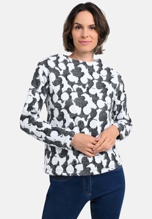 Black and white patterned knit sweater with long sleeves and a round neckline, featuring a textured, fluffy fabric and subtle detailing.