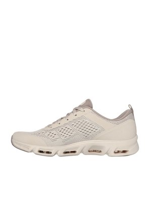 Zapatilla deportiva de color beige claro con parte superior de malla y sintético, cuello acolchado, diseño de encaje y suela acolchada con bolsillos de aire visibles.