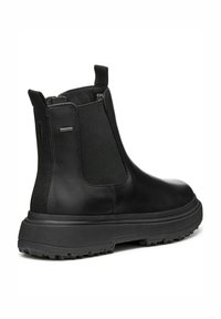 Botines negros de cuero con paneles laterales elásticos, suela gruesa texturizada y tiradores para facilitar su uso. Acabado suave con detalles de goma.