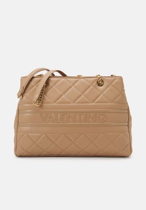 Beige gesteppte Leder-Handtasche von Valentino mit goldenen Kettenriemen und geprägtem Logo, das zentral auf dem Vorderpanel platziert ist.