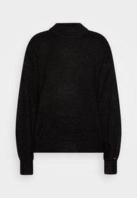Pull en tricot noir avec un col haut, épaules tombantes et poignets côtelés. Détail subtil du logo sur la poitrine, texture douce partout.