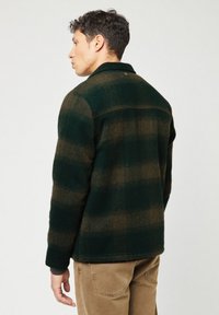 Grøn og brun rutet flanneljakke med krave, knapdetaljer og ribbede manchetter, lavet af blødt, struktureret materiale. Slim fit.