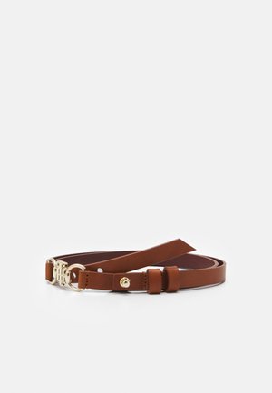 Ceinture en cuir marron avec boucle dorée et sangle ajustable posée à plat sur un fond blanc.