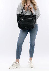 Sac fourre-tout en cuir noir à surface texturée, poche avant zippée, double bandoulière et ferrures argentées.