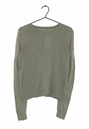 Sweater à manches longues de couleur olive avec des poignets côtelés et des sections en tissu en maille sur le haut des manches, suspendu à un cintre noir sur fond blanc.