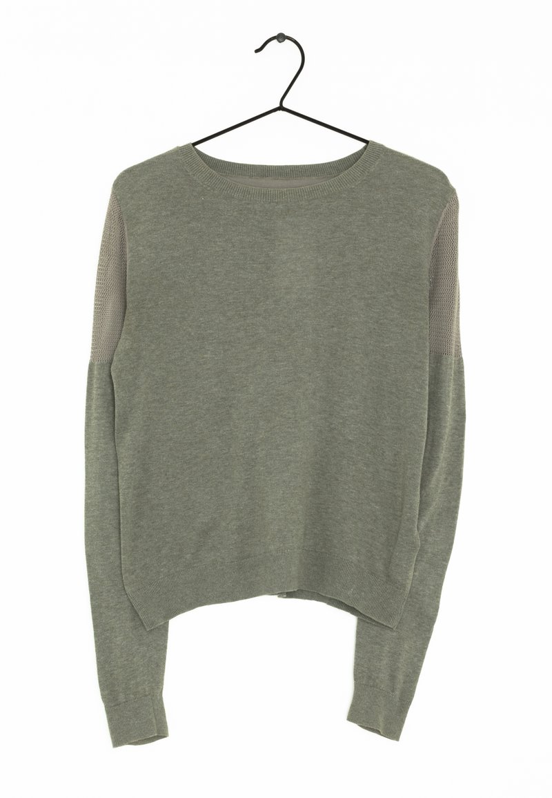 Zielona oliwkowa swetra z długim rękawem, z prążkowanymi mankietami i siateczkowymi wstawkami na górnych rękawach, wisząca na czarnej wieszaku na białym tle.