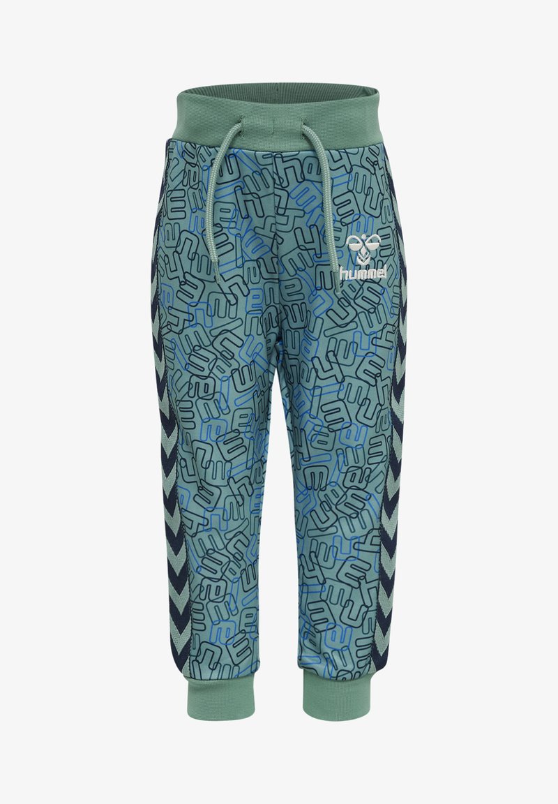 Gröna joggingbyxor med ett abstrakt blått mönster, elastisk midja med dragsko, marinblå sidosträck med chevrondetaljer och logotypdetalj.