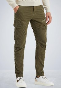Olivgrüne Cargo-Hosen verfügen über mehrere Taschen, ein schlankes Design und eine weiche Textur, kombiniert mit weißen und schwarzen Sneakers.