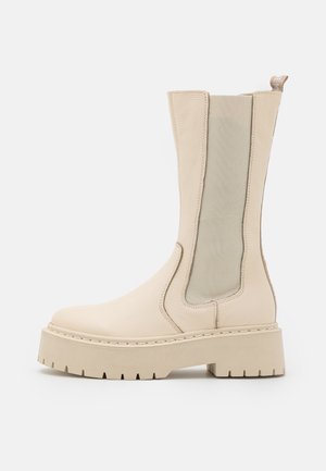 Beżowe botki za kostkę z teksturowanej skóry, z elastycznymi bocznymi panelami i masywną podeszwą platformową o wytrzymałym bieżniku.