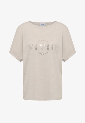 T-shirt beige à manches courtes avec col rond, présentant un texte argenté brillant « VIVID » avec un plus petit « DREAMS » au-dessus et en dessous sur le devant.