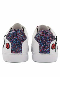 Baskets blanches avec une finition brillante, présentant un détail de talon pailleté en violet et rose, et un graphique de lèvre noire sur le côté.