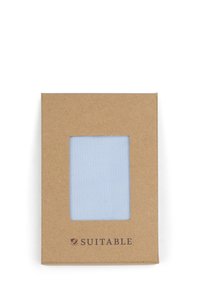 Lichtblauwe stofstaal weergegeven in een rechthoekige opening van een vierkante bruine kartonnen verpakking. "SUITABLE" logo gedrukt aan de onderkant.