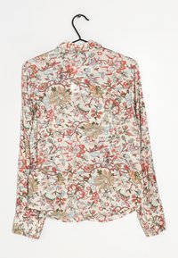 Pitkähihainen kukkapaita, jossa on vaalean kerma tausta ja punaisia, sinisiä ja vihreitä kukkia. Kevyt kangas, jossa on kaulus ja nappidetailit.