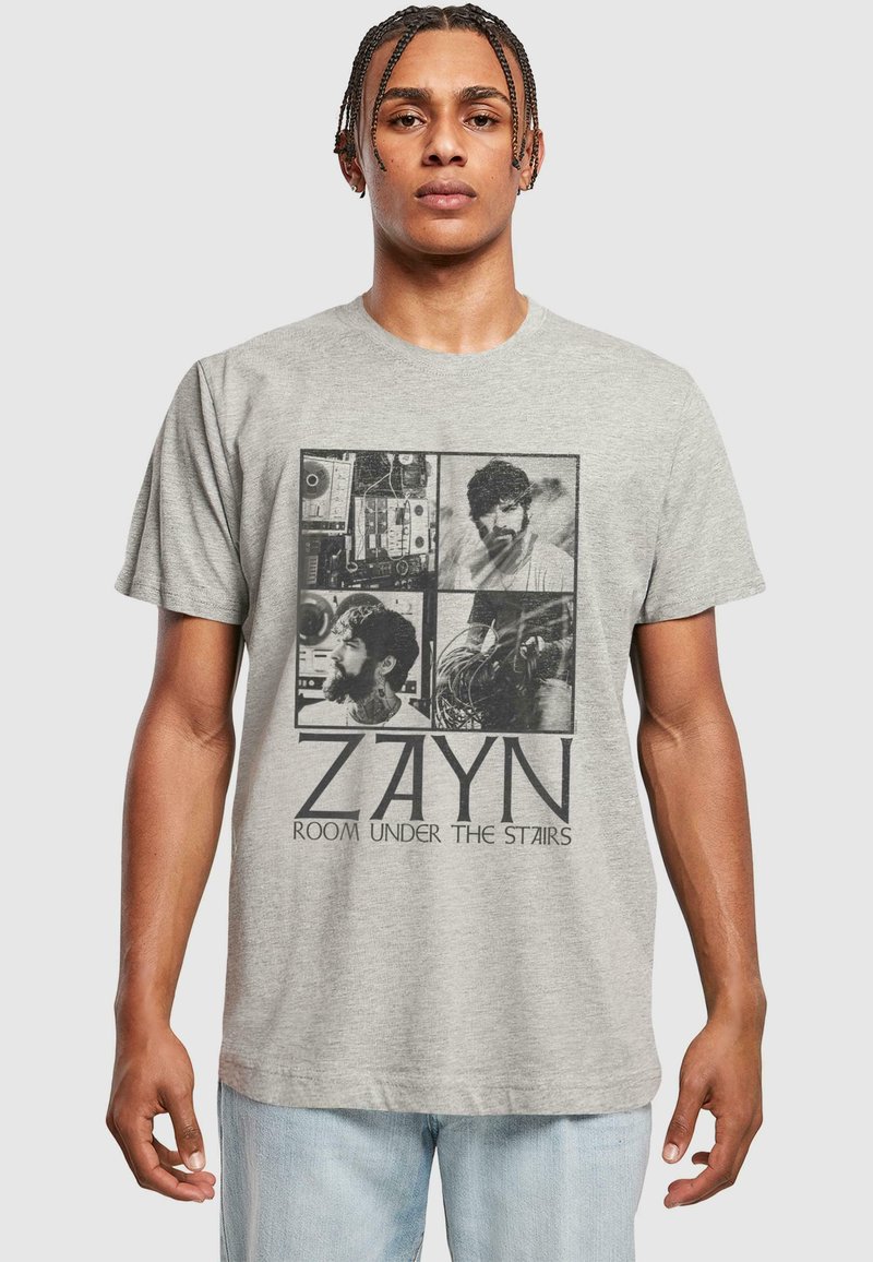 Pilkas medvilnės marškinėliai, kuriuos puošia keturi juodai baltų vaizdų koliažas ir tekstas "ZAYN ROOM UNDER THE STAIRS" ryškiu juodu šriftu.