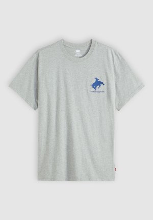 Hall hõbedane puuvillane t-särk lühikeste varrukatega, mille vasakul rinnal on sinine graafiline logo. Klassikaline ümar kaelus, sujuv tekstuur.