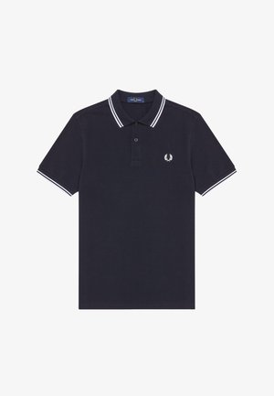 Mørkeblå polo skjorte i bomuld med hvid stribet krave og manchetter. Har et lille broderet logo på venstre bryst. Klassisk pasform, korte ærmer.
