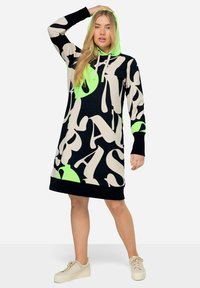 Zwarte hoodie-jurk met een gedurfde crème en neon groene abstracte letterafdruk. Heeft lange mouwen en een relaxte pasvorm, gemaakt van zachte stof.