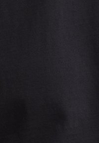 Υφή υφάσματος από μαύρο υλικό με διακριτικές σκιές και πτυχώσεις, που δείχνει μια λεία, ματ επιφάνεια.