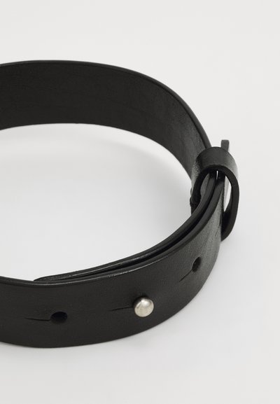 Svart läderbälte med en slät yta, försett med en metallnubb och flera justeringshål, med en ögla i änden för fäste.