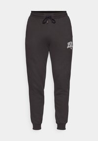 Zwarte sweatpants van zacht materiaal, met een elastische tailleband, geribbelde cuffs en een wit logo op het linkerbeen.