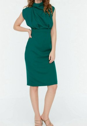 Türkisfarbenes Kleid mit drapiertem, hohem Ausschnitt und kurzen Ärmeln, figurbetonte Silhouette, knielang, glatter Stoff, kombiniert mit nudefarbenen High Heels.