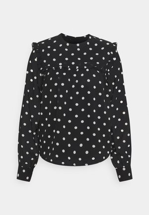 Schwarze Bluse mit weißen Polka-Dots, langen Ärmeln, gerafftem Ausschnitt und schmal zulaufenden Manschetten. Glatter Stoff mit lockerem Sitz.