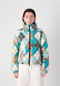 Quilted pufferjakke med et blåt, brunt og hvidt argylemønster, høj krave og lynlåsclosure, samt elastiske manchetter og kant.