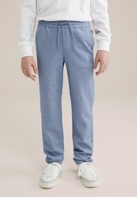 Mėlynos sportinės kelnės, pagamintos iš minkštos, tekstūruotos medžiagos, su elastinga juosmens juosta, reguliuojamu raiščiu ir šoninėmis kišenėmis.