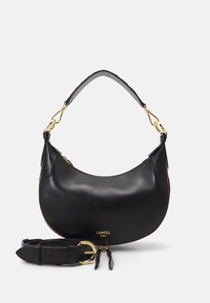 Black leather handbag with a curved shape, gold hardware accents, and adjustable belt-style strap. Features a zip closure and logo detailing.