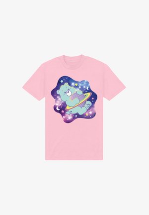 Lyserød T-shirt med en tegneserie-arbejdsbjørn i rummet, som holder en stribet planet, sat mod en blå og lilla stjernehimmel med stjerner og måner.