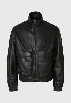 Sort læderjakke med høj krave, to frontlommer med klap, elastiske manchetter og talje. Glat tekstur, lynlås lukning foran.