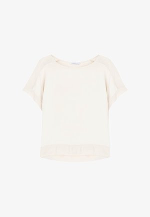 Luźna, kremowa bluzka z krótkim rękawem, okrągłym dekoltem i lekko zaokrąglonym dołem na białym tle.