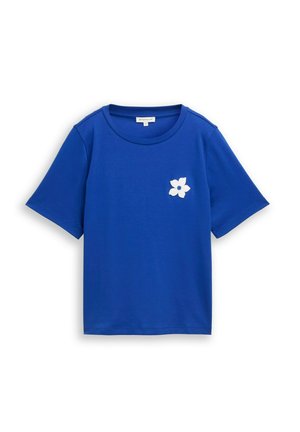 T-shirt bleu à manches courtes avec col rond et petit motif de fleur blanche sur la poitrine gauche.
