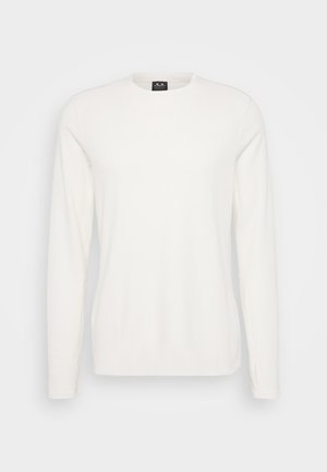 Valge pika varrukaga särk ümmarguse kaelusega, pehmest kangast, millel on rinnal väike logo ja sobivad varrukad.