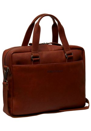 Serviette en cuir marron avec deux anses supérieures, fermeture éclair, poche avant et bandoulière ajustable. Texture lisse avec une marque discrète.
