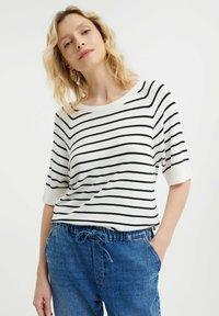 Gestreepte korte mouw top in witte en zwarte katoen, met een relaxte pasvorm en brede halslijn, gecombineerd met blauwe broek met trekkoord.