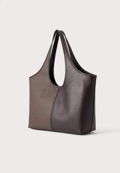 Sac cabas marron bicolore avec de longues anses d’épaule, doté d’un panneau à motif monogramme et d’un panneau en cuir grainé.