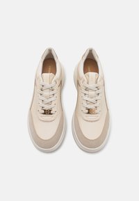 Beige joggesko med en glatt læroverdel, semsket detaljer, rund tå og snøring. Har et lite logo-merke på tungen og en polstret såle.