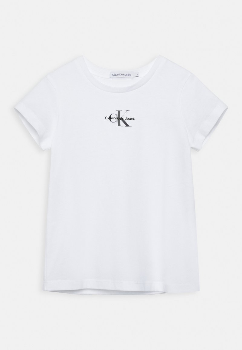 Camiseta de algodón blanca con cuello redondo y mangas cortas. Presenta un logo negro de "Calvin Klein Jeans" con una letra "K" estilizada.